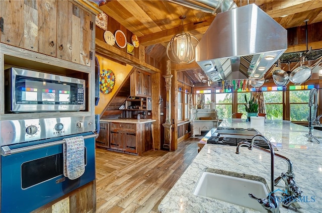 kitchen featuring light hardwood / wood-style floors, stainless steel appliances, light stone counters, and island exhaust hood