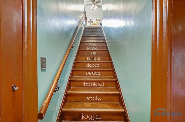 staircase featuring ceiling fan