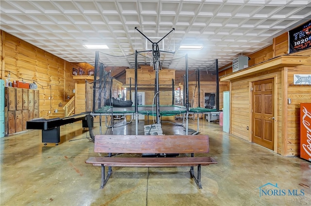 dining space with wood walls and concrete floors