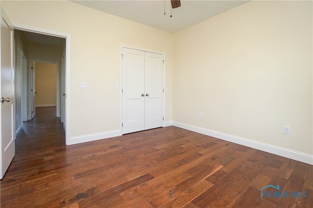 unfurnished bedroom with ceiling fan, dark hardwood / wood-style floors, and a closet