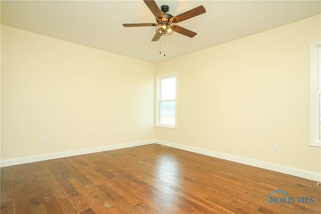 empty room featuring dark hardwood / wood-style flooring and ceiling fan