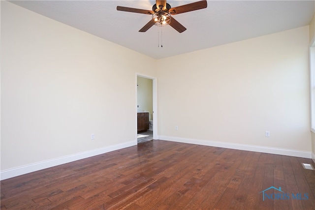 spare room with ceiling fan and dark hardwood / wood-style floors