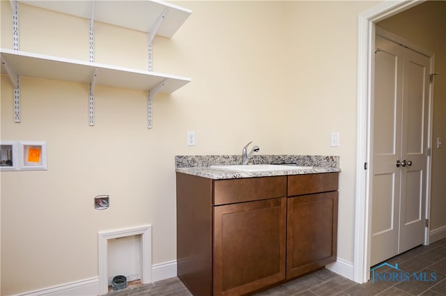 clothes washing area with dark hardwood / wood-style floors and sink