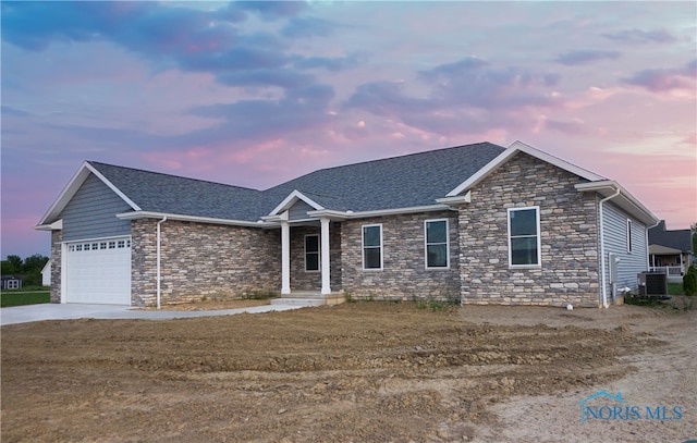 view of front of property with a garage and central air condition unit