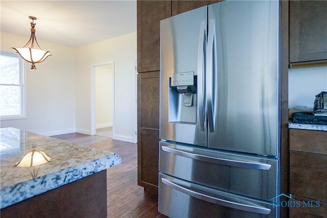 kitchen featuring decorative light fixtures, dark hardwood / wood-style floors, dark brown cabinetry, and stainless steel refrigerator with ice dispenser