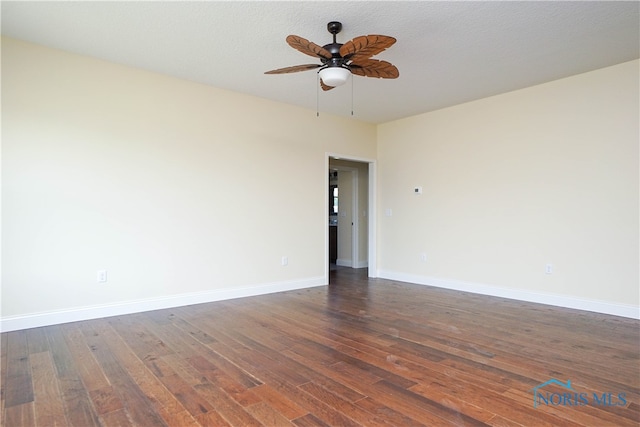 spare room with dark hardwood / wood-style flooring, ceiling fan, and a textured ceiling