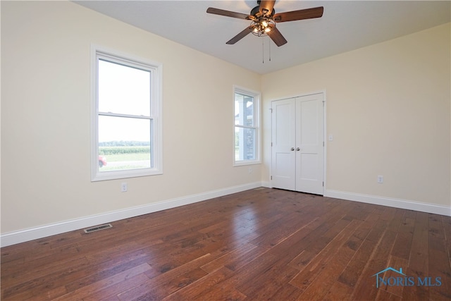 unfurnished room with dark wood-type flooring and ceiling fan