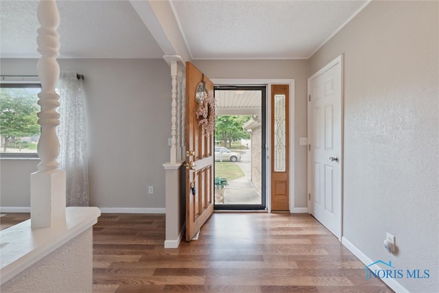 entryway with wood-type flooring and a textured ceiling