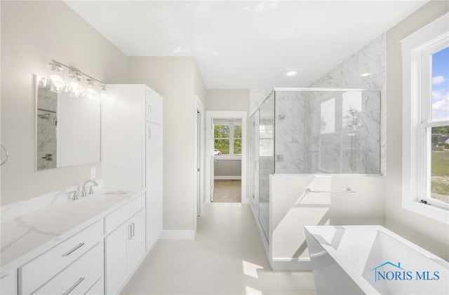 full bath with vanity, a soaking tub, a stall shower, and a healthy amount of sunlight