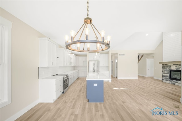 kitchen featuring appliances with stainless steel finishes, an inviting chandelier, white cabinetry, and hanging light fixtures