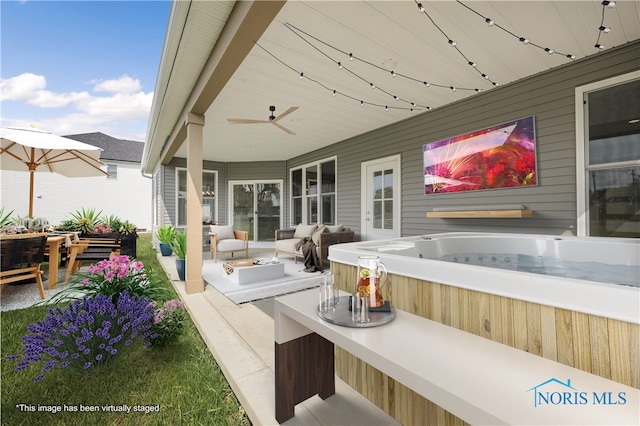 view of patio / terrace featuring ceiling fan and a hot tub