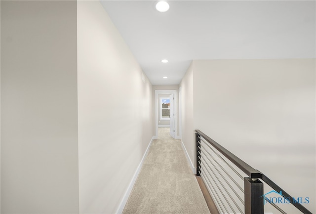 hall featuring light colored carpet, baseboards, and recessed lighting