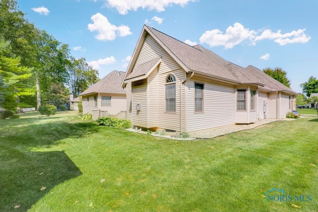 view of side of property with a lawn