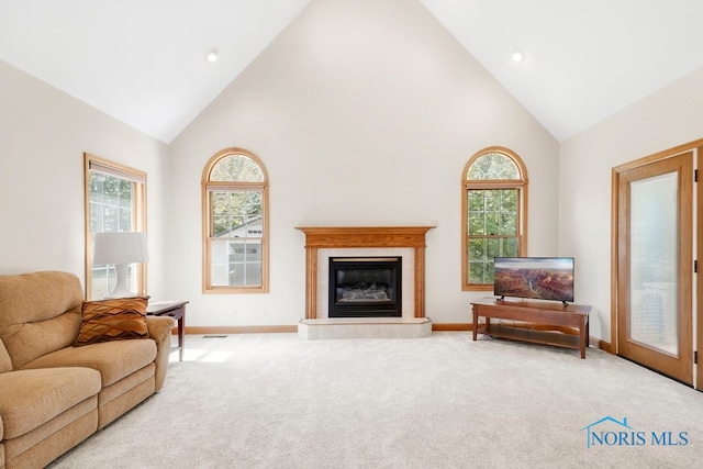 carpeted living room featuring high vaulted ceiling and a fireplace