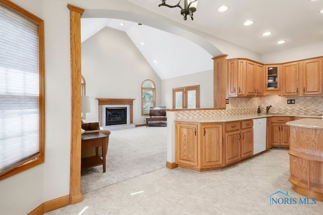 kitchen featuring dishwasher, a chandelier, lofted ceiling, kitchen peninsula, and decorative backsplash