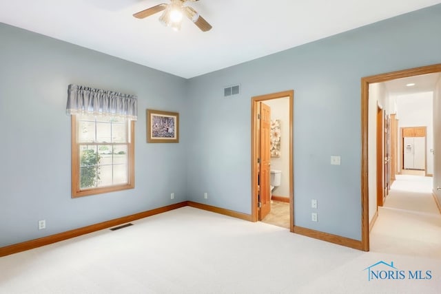 unfurnished bedroom featuring ensuite bath, ceiling fan, and light colored carpet