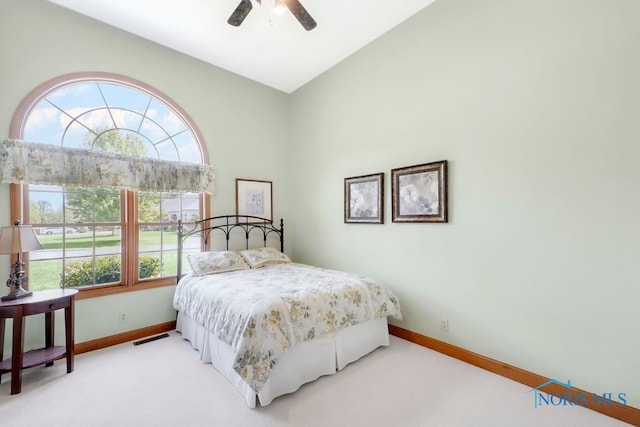 bedroom with carpet flooring, ceiling fan, and high vaulted ceiling