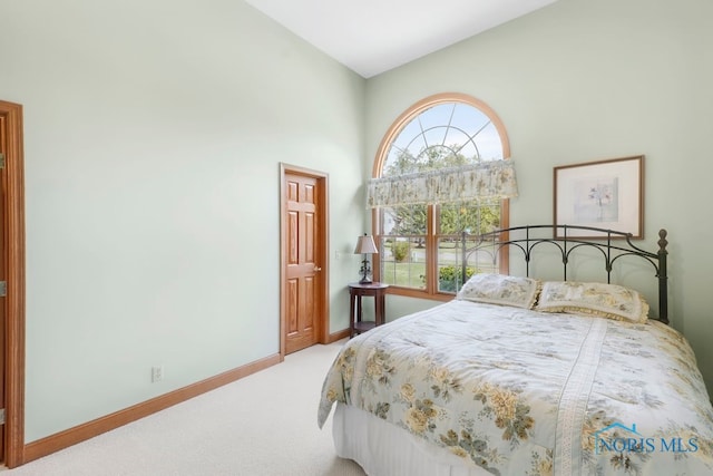 carpeted bedroom featuring multiple windows and high vaulted ceiling