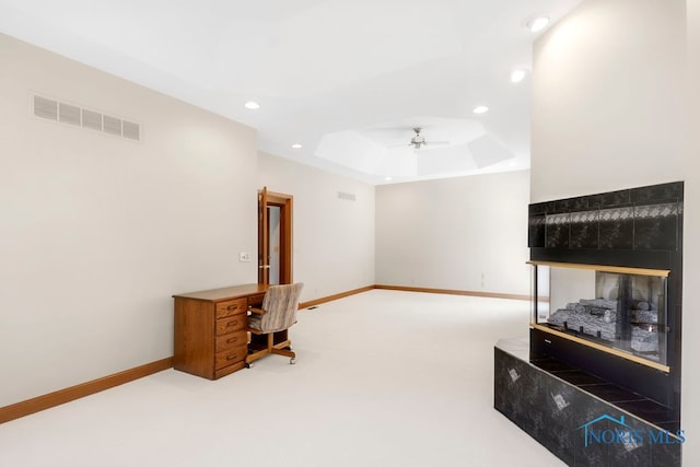 office with ceiling fan, a raised ceiling, and carpet