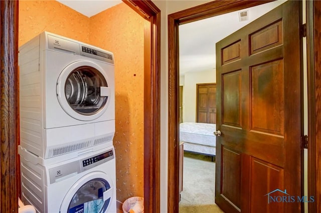 9740 Maumee Western Rd, Monclova, OH 43542 - clothes washing area featuring visible vents, carpet floors, stacked washer and clothes dryer, and laundry area