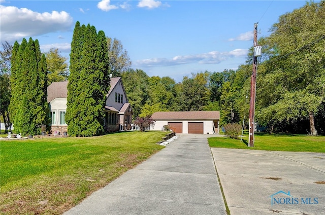 view of front of house featuring a front lawn, an outdoor structure, and a garage