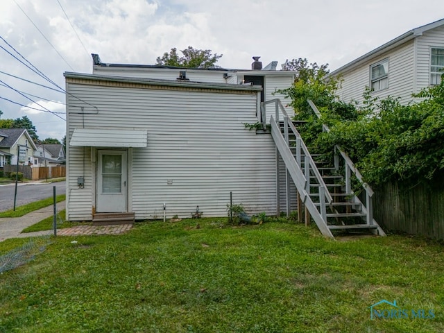 rear view of house featuring a yard