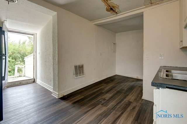 interior space with a textured ceiling, dark wood-type flooring, and plenty of natural light