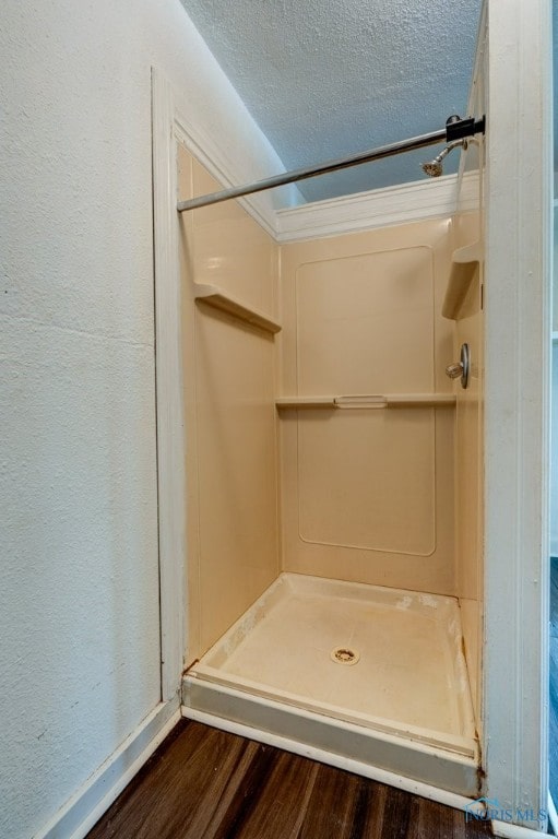 bathroom with walk in shower, hardwood / wood-style flooring, and a textured ceiling