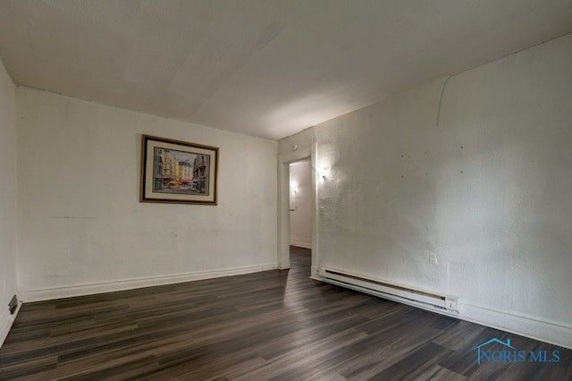 unfurnished room with a baseboard radiator and dark hardwood / wood-style floors