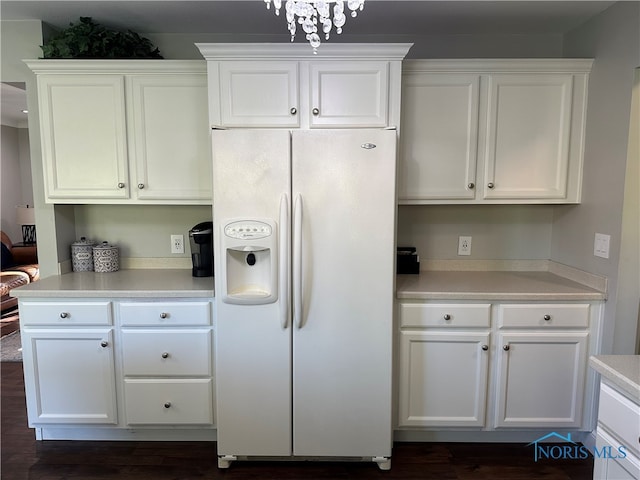 kitchen featuring white fridge with ice dispenser, dark hardwood / wood-style floors, and white cabinets