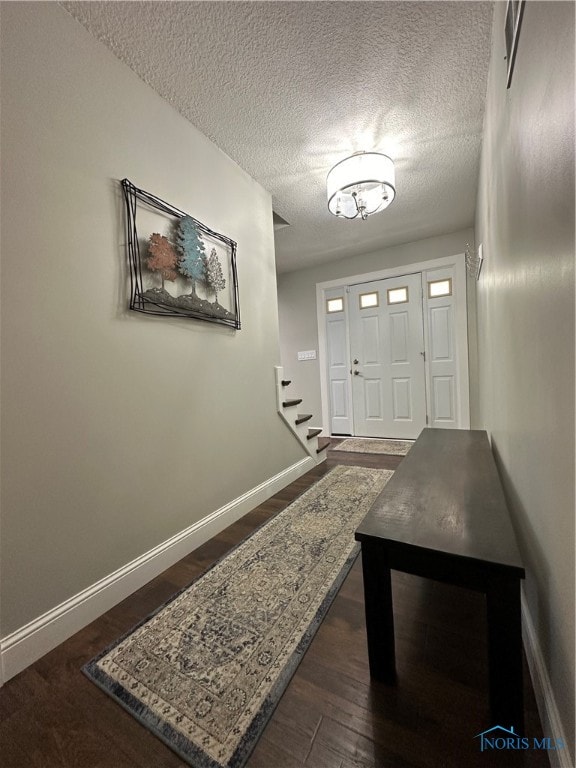 entryway featuring a textured ceiling and dark wood-type flooring