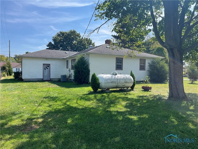 back of property with a lawn and cooling unit