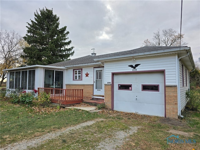 view of front of property with a garage and a sunroom