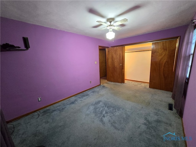 unfurnished bedroom featuring a closet, a textured ceiling, light colored carpet, and ceiling fan