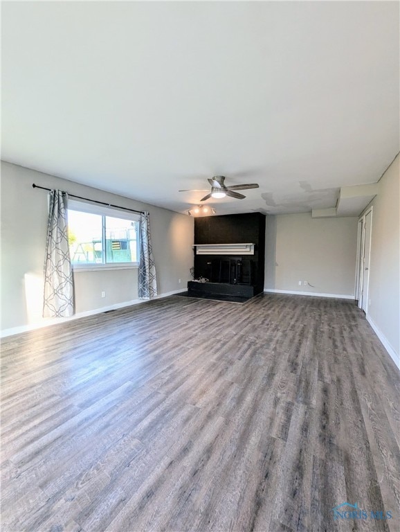 unfurnished living room with wood-type flooring and ceiling fan