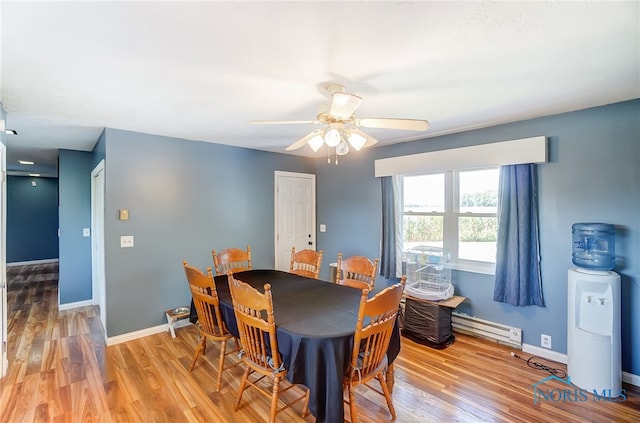 dining area featuring a baseboard radiator, ceiling fan, and light hardwood / wood-style flooring