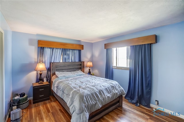 bedroom with wood-type flooring and a textured ceiling