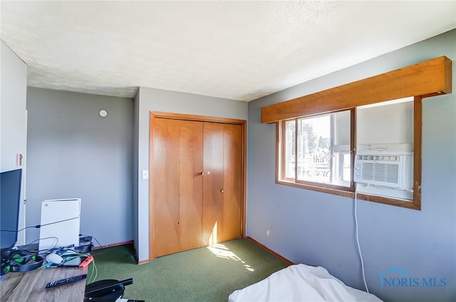 bedroom with carpet, a textured ceiling, cooling unit, and a closet