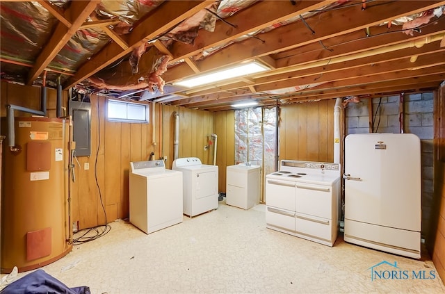 basement featuring wood walls, white fridge, washer and clothes dryer, water heater, and electric panel