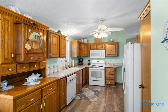 kitchen featuring white appliances, sink, wood-type flooring, ceiling fan, and a textured ceiling