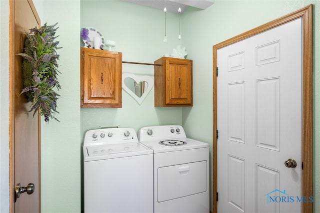 laundry room featuring washer and dryer and cabinets