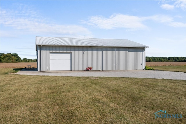 garage featuring a lawn and a rural view