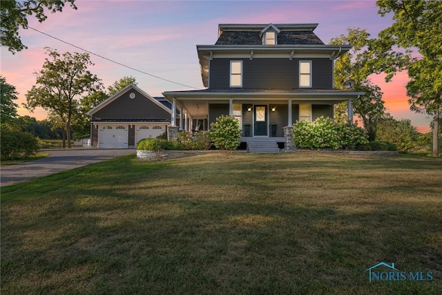 view of front of house with a lawn, a porch, and a garage