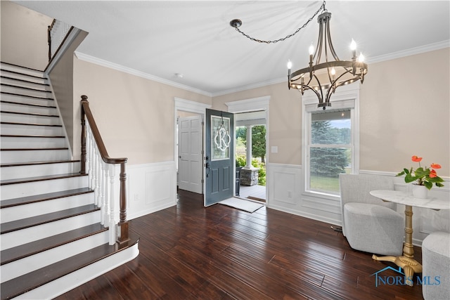 foyer entrance featuring an inviting chandelier, dark wood-type flooring, and crown molding