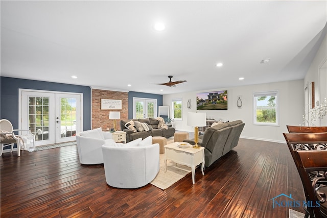 living room with a wealth of natural light, ceiling fan, french doors, and dark hardwood / wood-style flooring