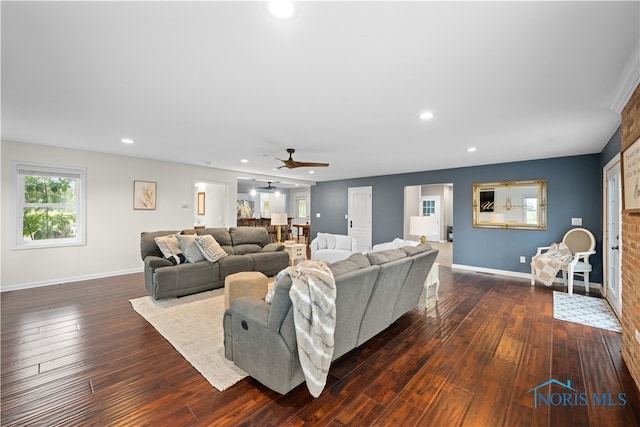 living room featuring ceiling fan and dark hardwood / wood-style floors