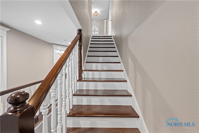 stairs featuring hardwood / wood-style floors