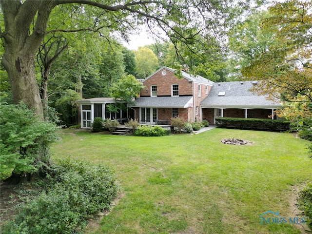 rear view of house featuring a yard