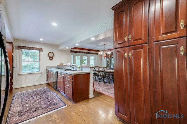 kitchen with pendant lighting, a notable chandelier, light hardwood / wood-style flooring, and plenty of natural light