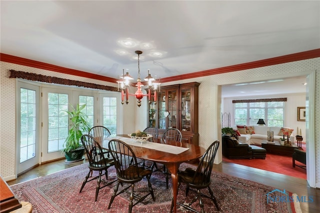 dining room featuring an inviting chandelier, hardwood / wood-style flooring, and crown molding